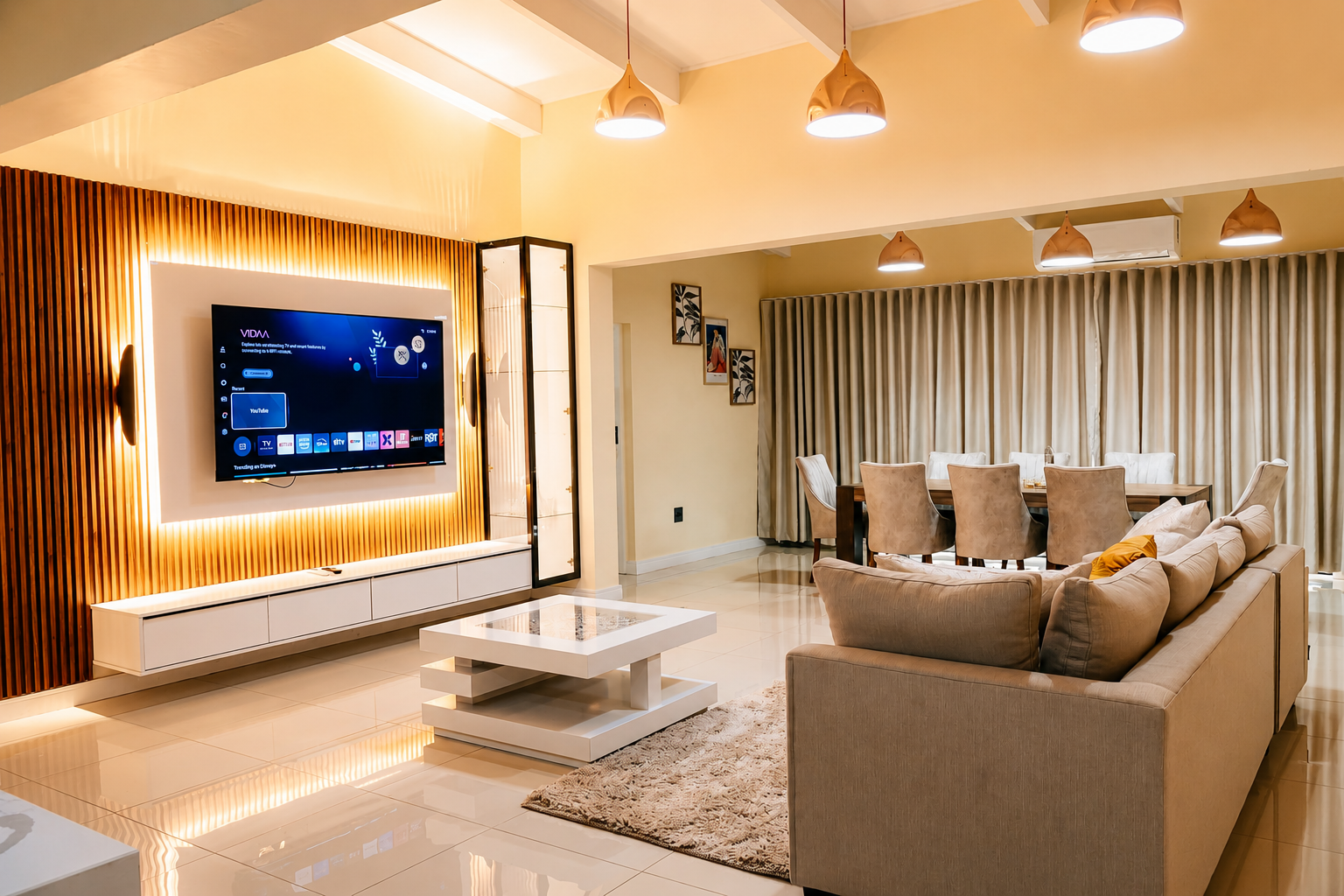 Living room and dining area with backlit timber TV wall