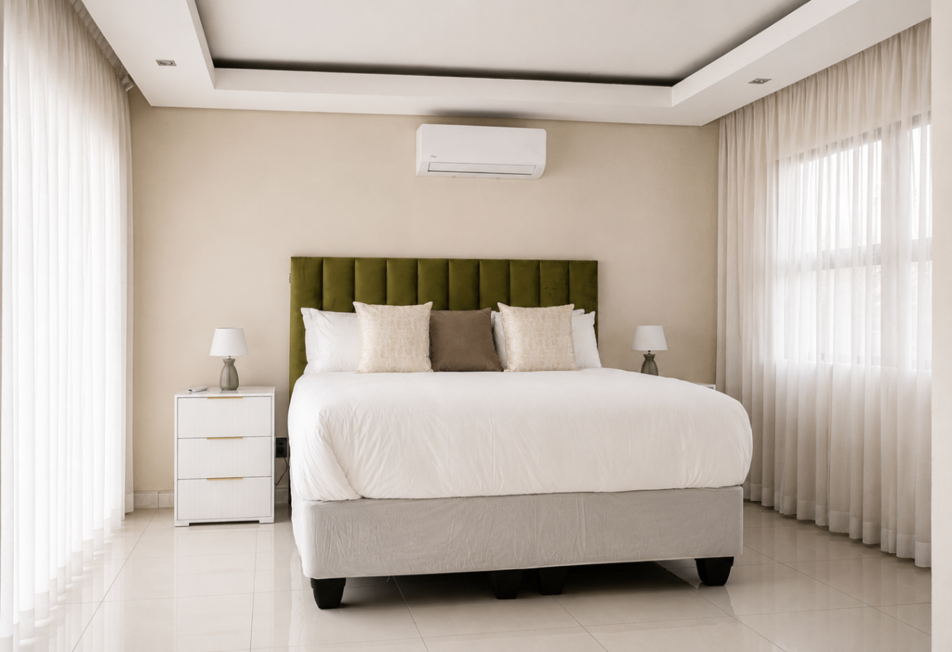 Bedroom with olive velvet headboard and layered linens