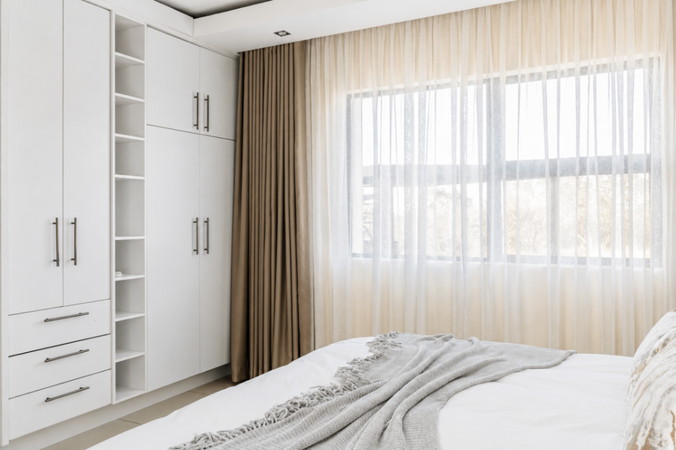 Bedroom with fitted wardrobes and soft draping