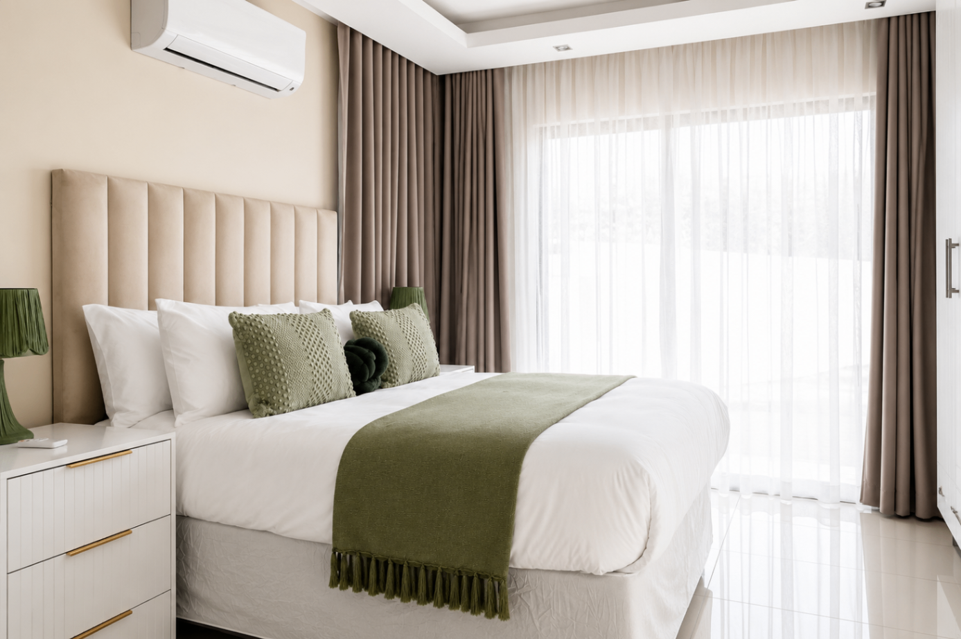 Bedroom with green throw and floor-to-ceiling curtains